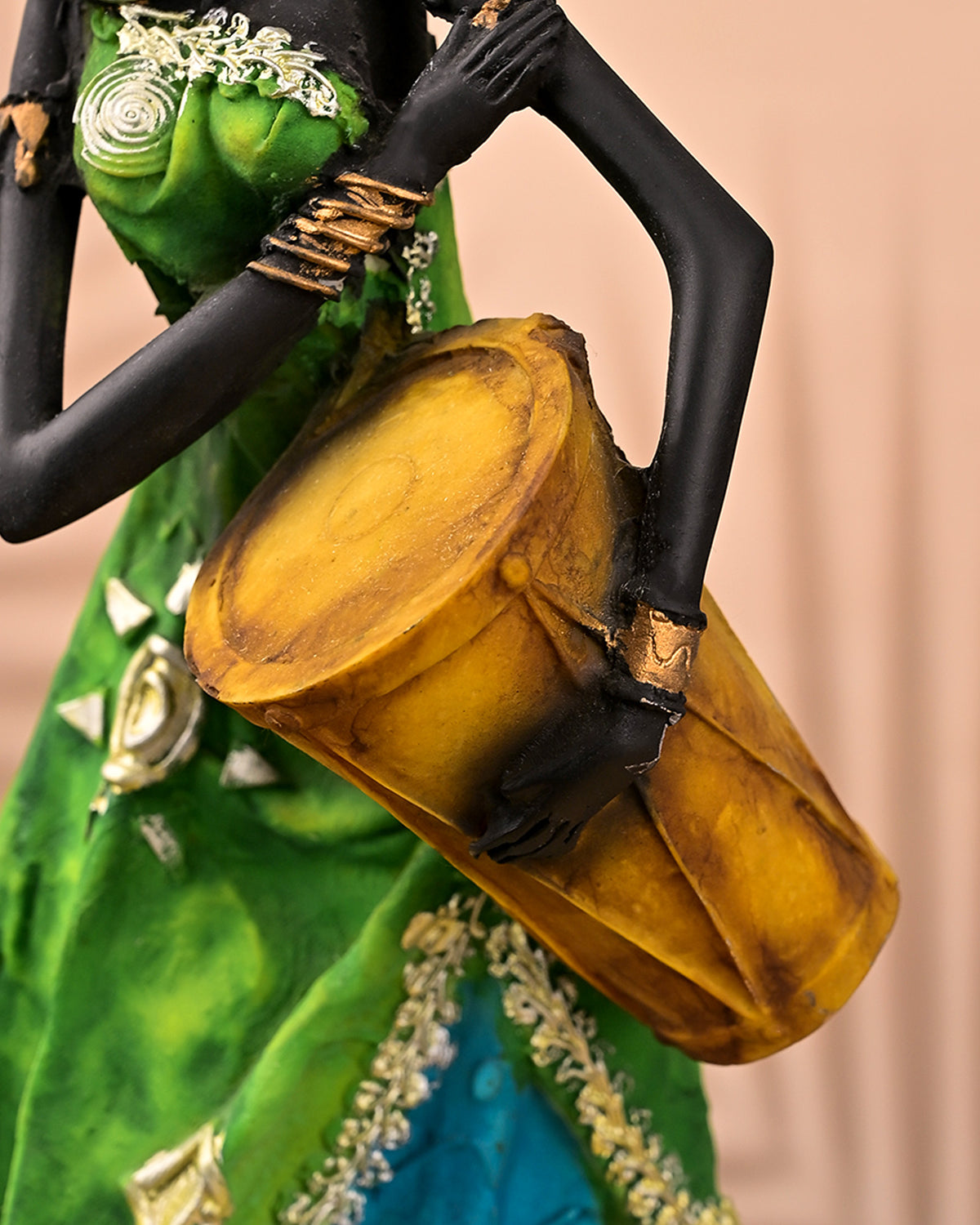 African woman sculpture holding a traditional drum