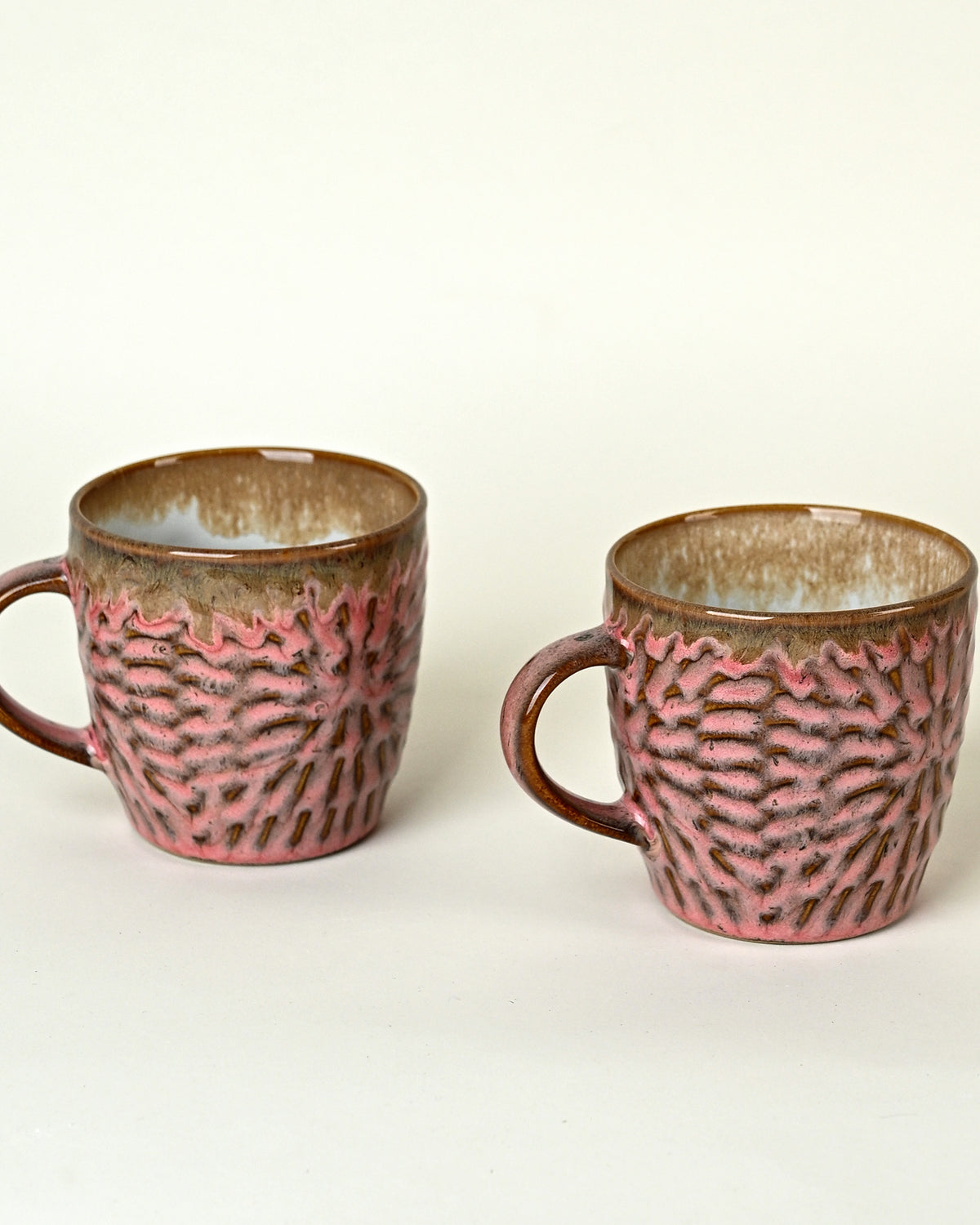 Set of two dusty rose pink ceramic tea cups arranged beautifully on a table