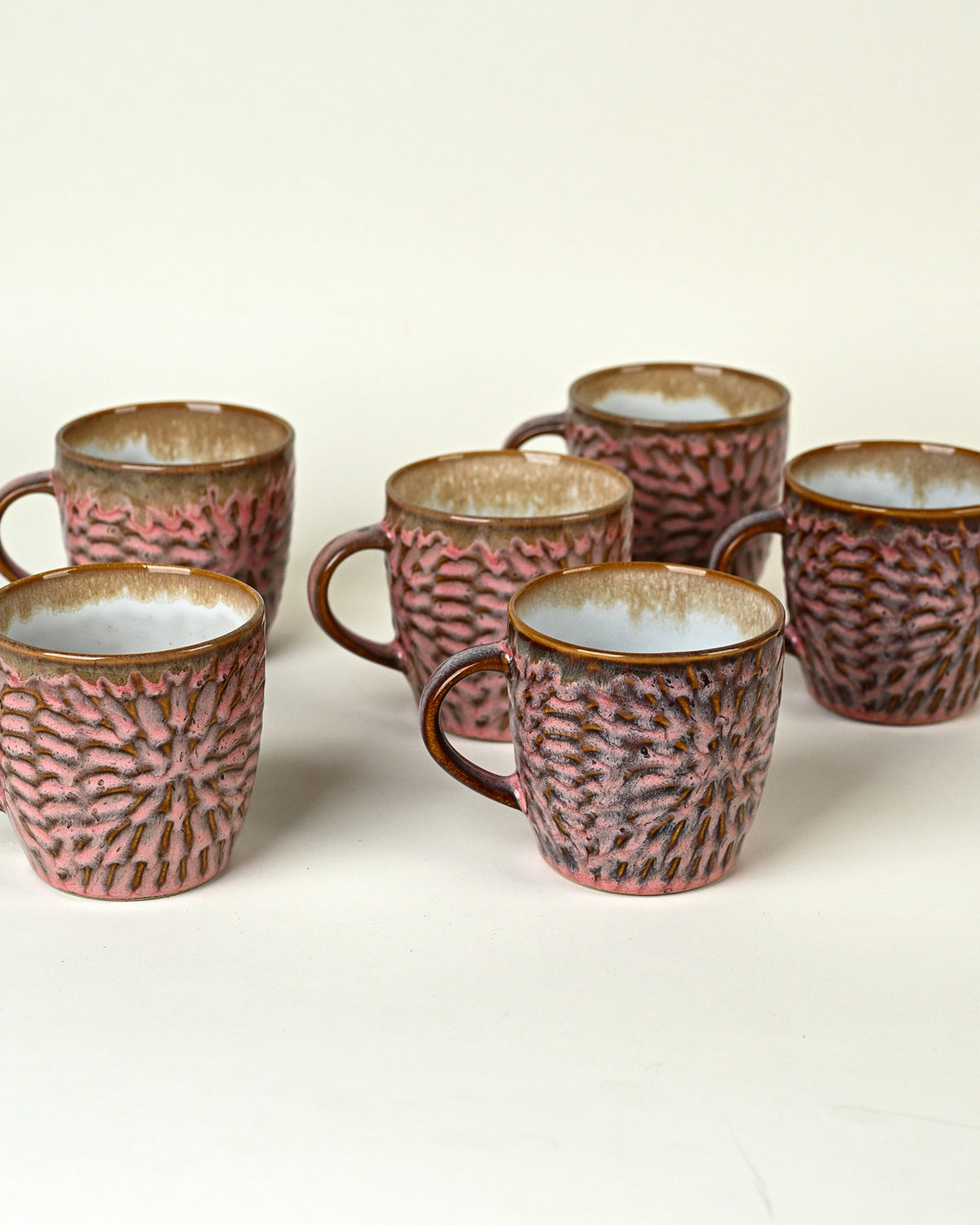 Set of six dusty rose pink ceramic tea cups arranged beautifully on a table