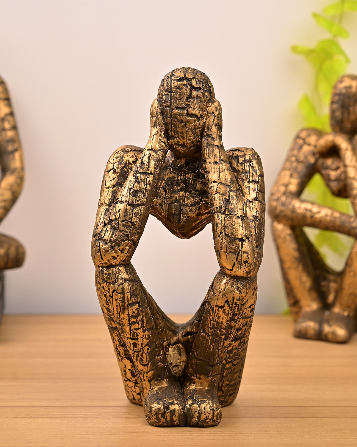 Elegant gold trio figurine set featuring thoughtful poses