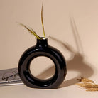 Contemporary black donut vase with a sleek finish

