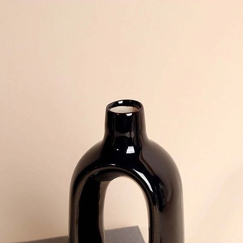 Minimalist black vase with a unique open hollow shape


