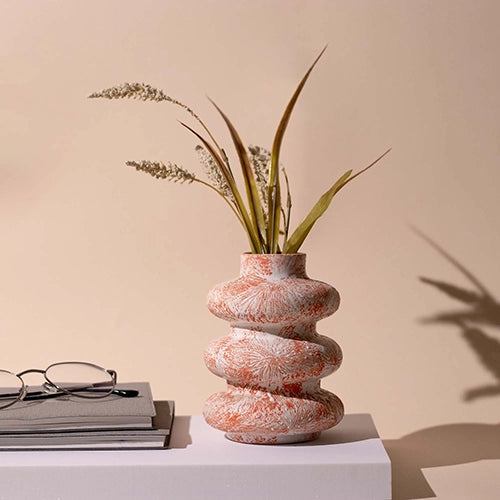 Burnt orange tri-ring ceramic vase with modern sculptural design

