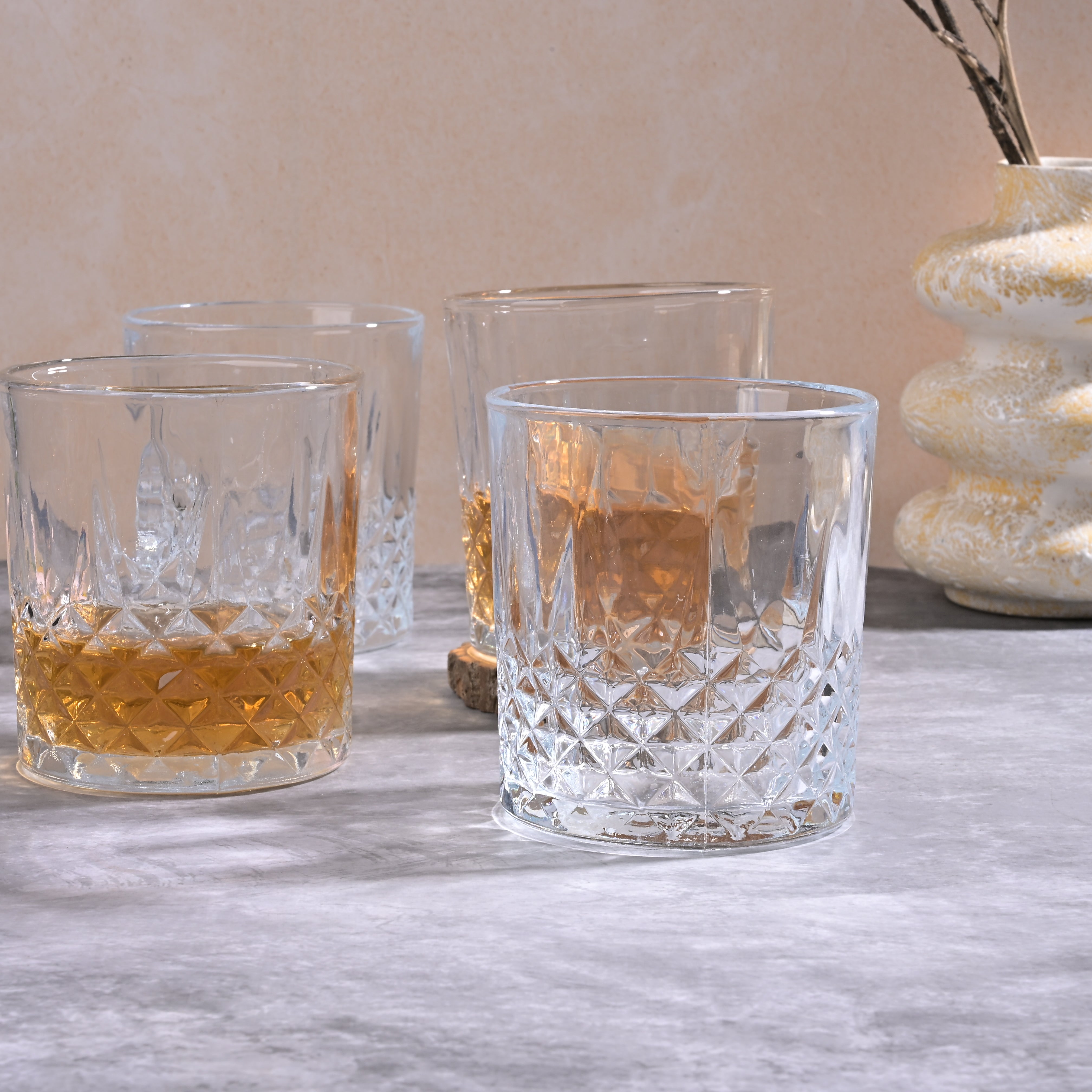 Four classic whiskey glasses displayed on a table

