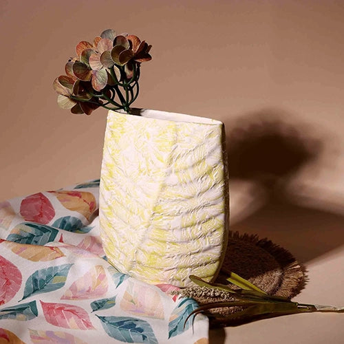 Modern cream vase featuring an embossed leaf pattern

