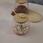Clear glass jar with wooden cover for food storage
