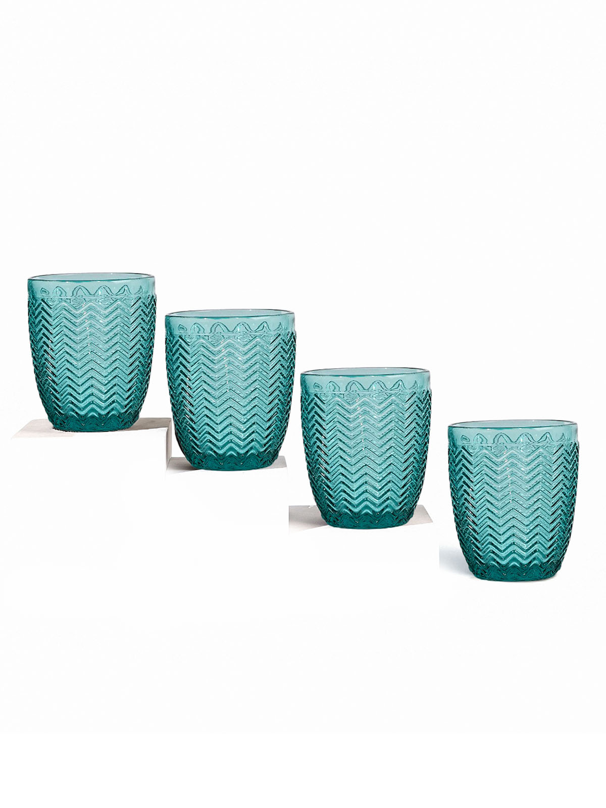 Four Midori clear drinking glasses on display

