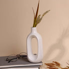 Minimalist white hollow vase with modern sculptural design


