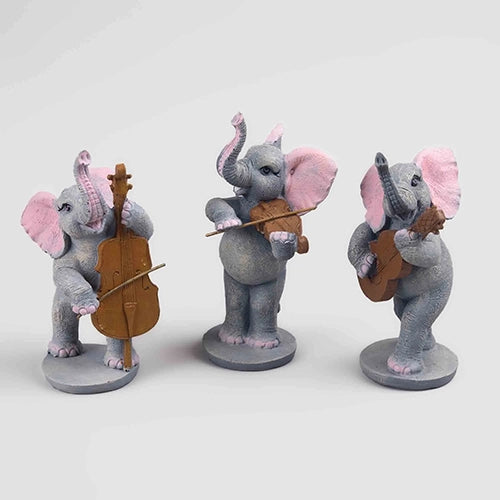 Three musical elephant figurines playing instruments

