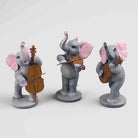 Three musical elephant figurines playing instruments

