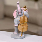 Three elephants playing instruments in a decorative statue set

