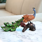 Peacock on tree trunk statue with detailed feather design

