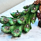 Artistic peacock sitting on a wooden tree trunk statue

