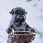 Decorative puppy statue nestled inside a basket

