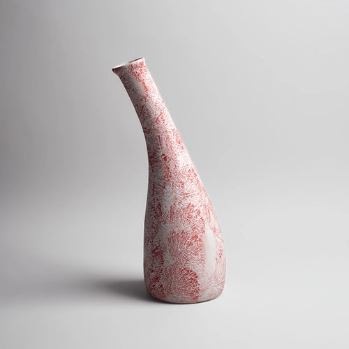 Decorative red and white vase featuring a textured finish

